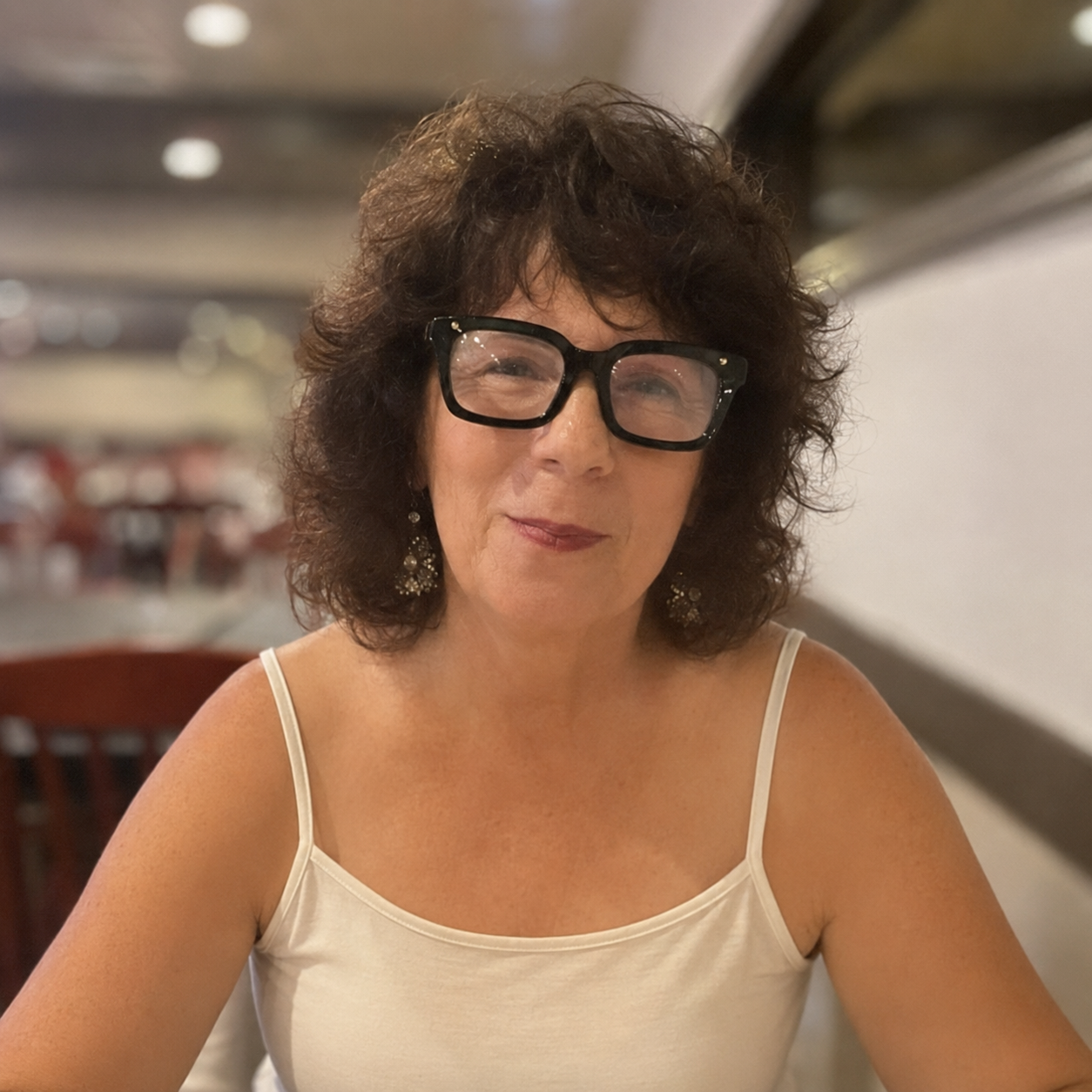 Portrait of L. Anne Greenspan seated at a restaurant